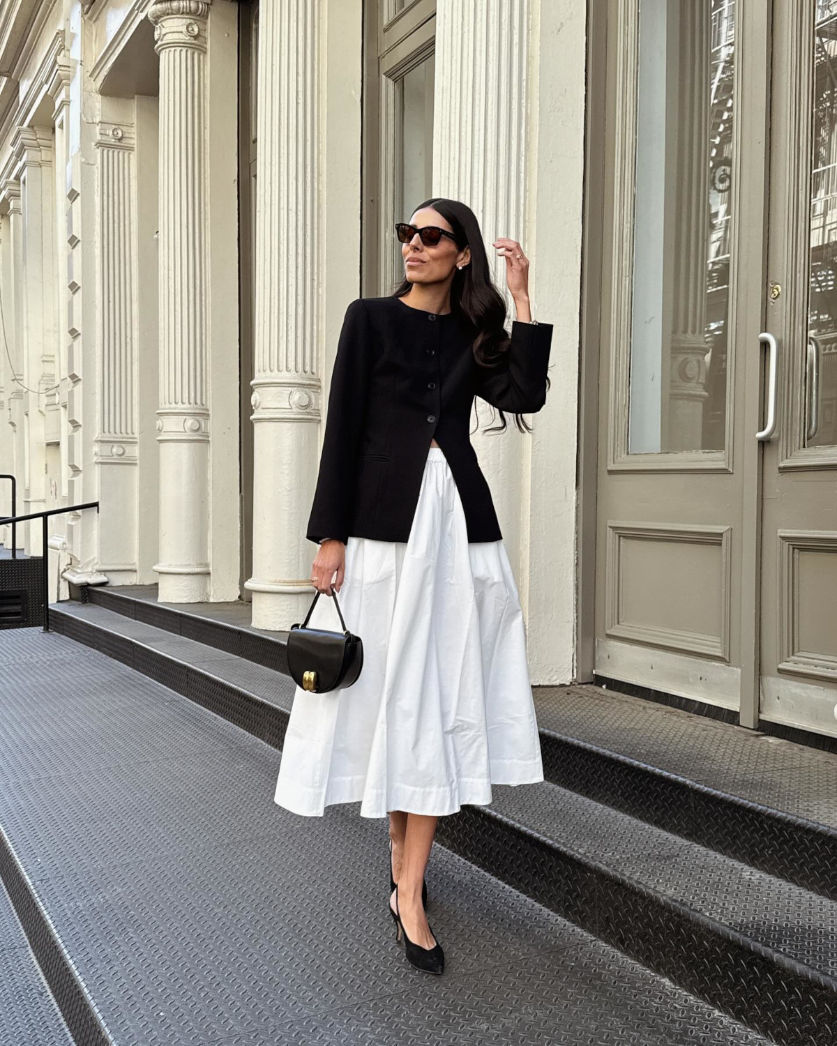 Woman in black blazer and white skirt