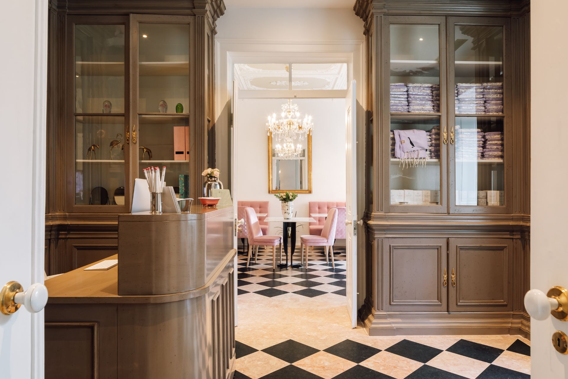 Bar with black and white diamond floor tiles, grey shaker cabinets, and pale pink velvet chairs