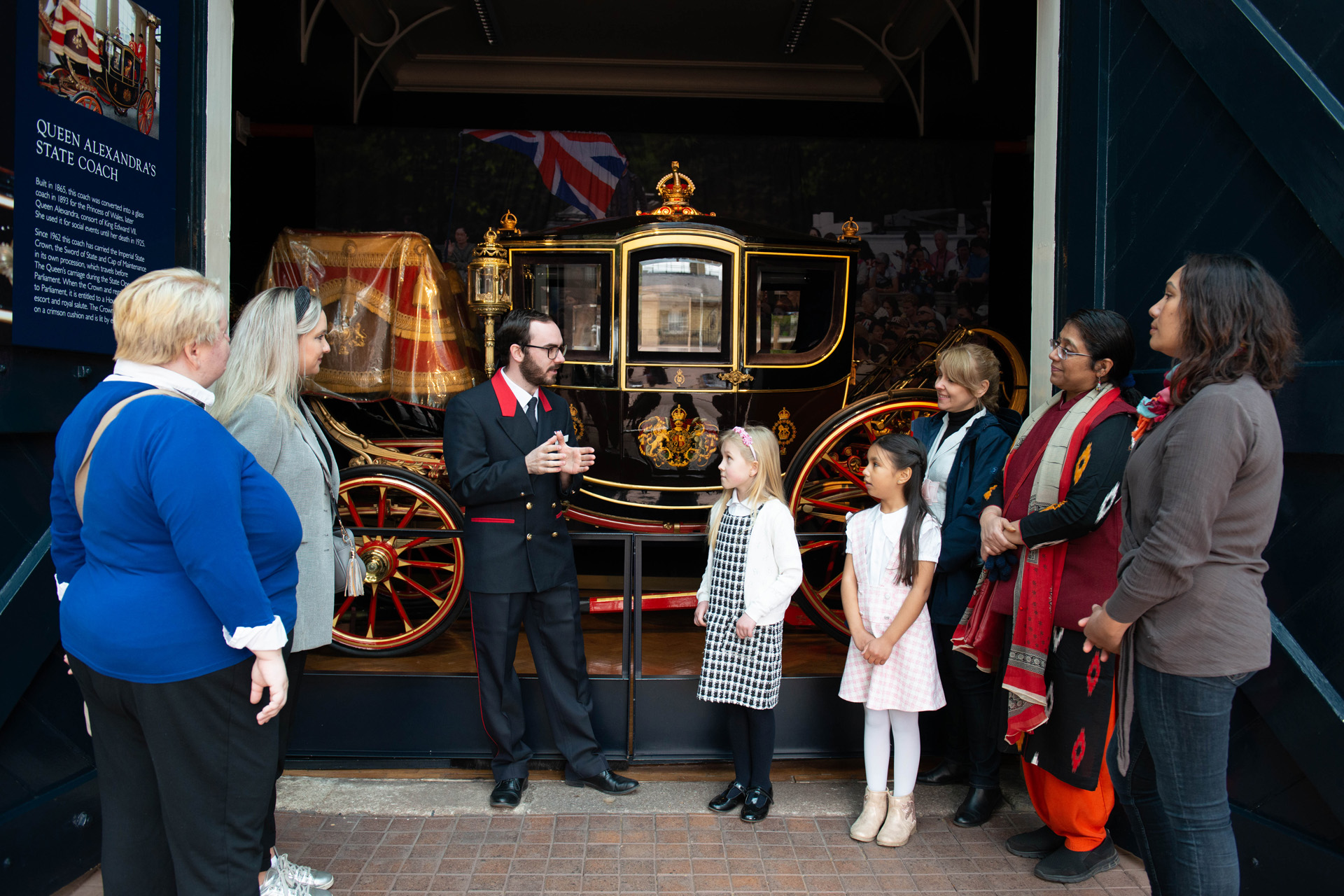 Children standing beside a coach at the Royal Mews