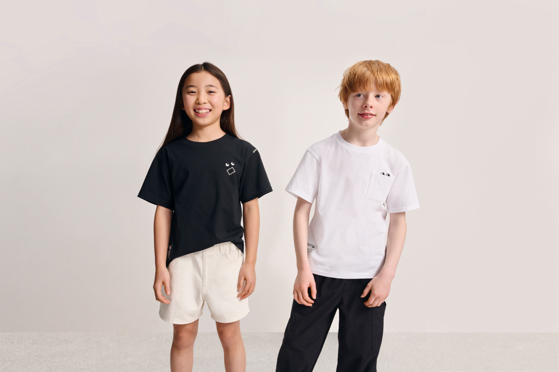 Two kids in Uniqlo x Anya Hindmarch tops