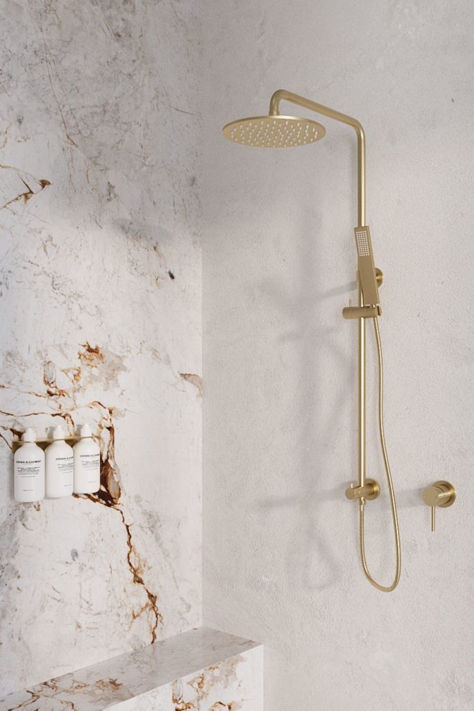 White marble shower with gold fixtures