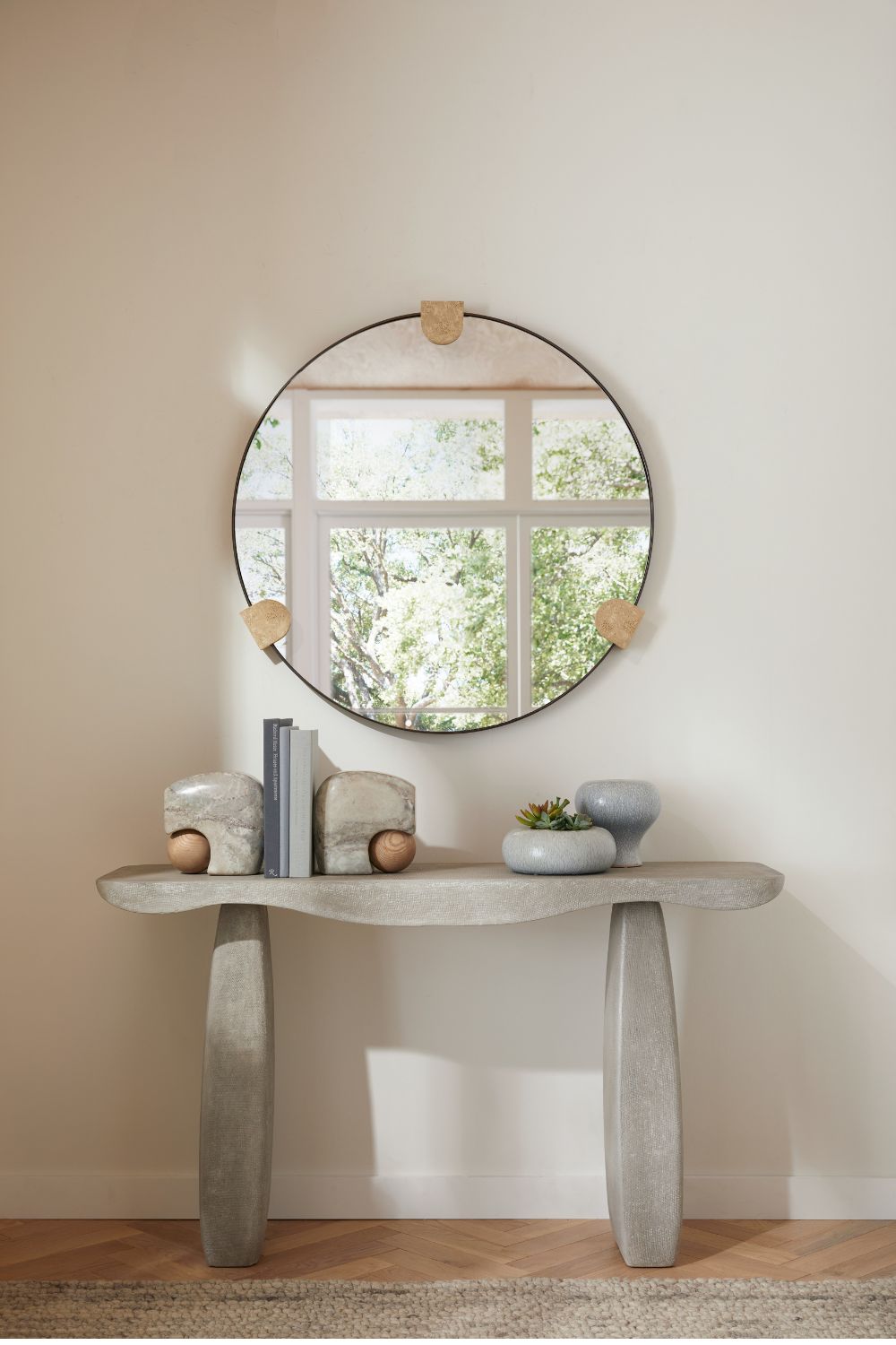 Hallway with curved grey stone table and circular mirror
