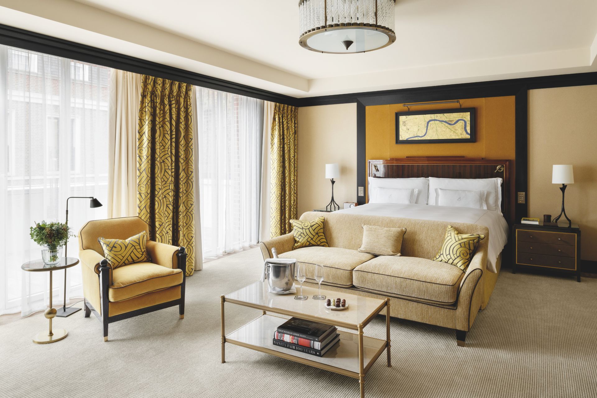 Mayfair hotel with taupe walls, a pale yellow sofa and a chandelier