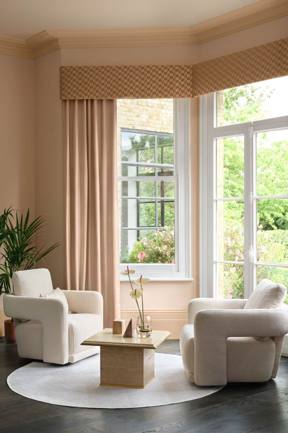 Peach living room with white boucle armchairs