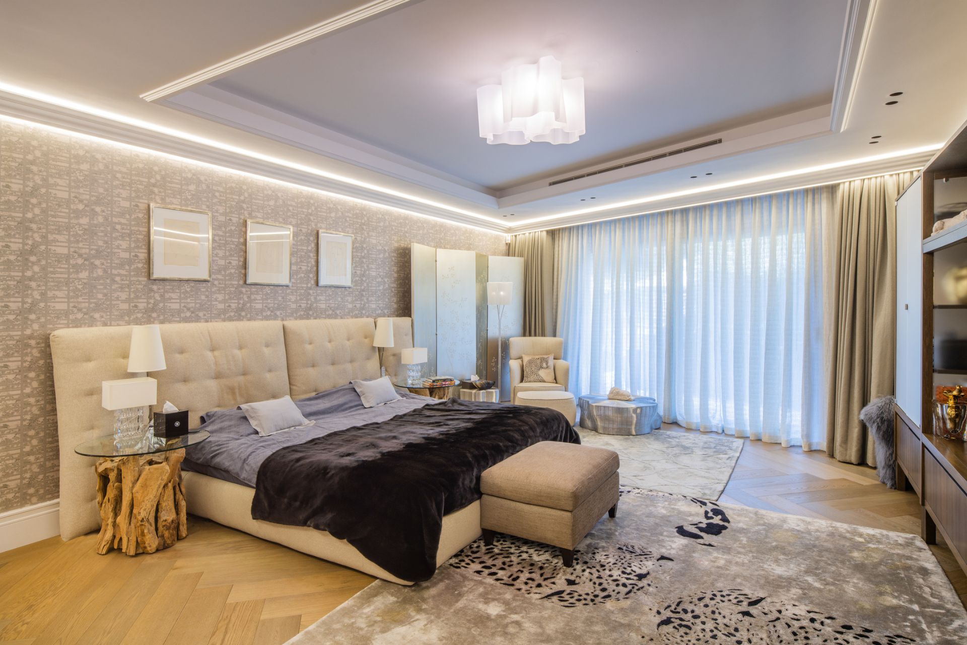 Bedroom with white leather headboard, a brown fur bedspread, and a grey rug