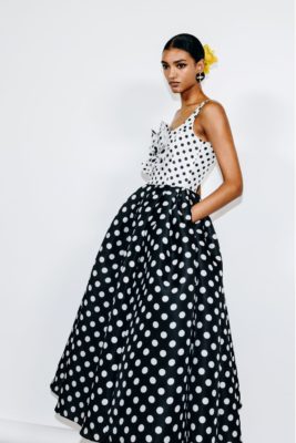 Model wearing yellow scrunchie and black and white polka dot maxi dress