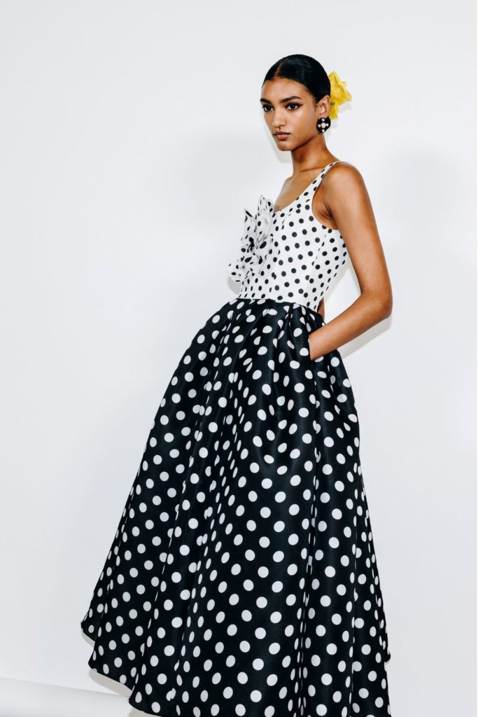 Model wearing yellow scrunchie and black and white polka dot maxi dress