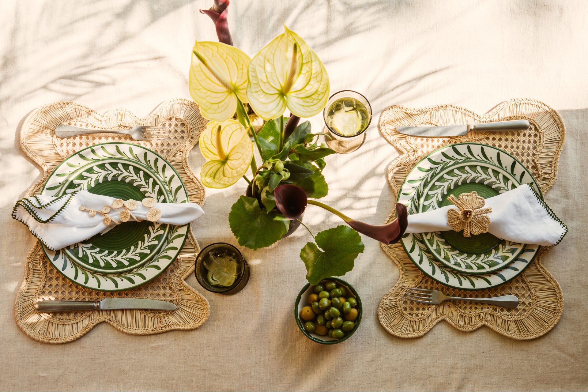 Beige tablecloth with rattan placemats and patterned green plates