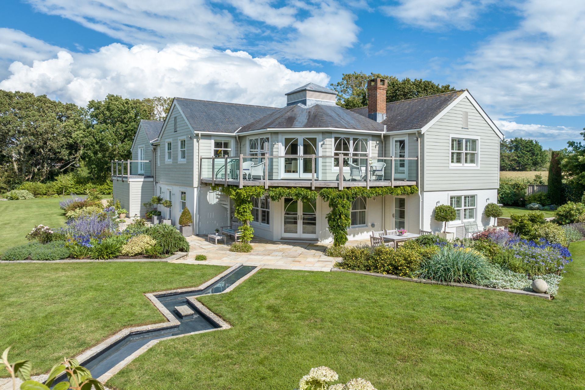 Weatherboarded colonial-style home with paved terrace