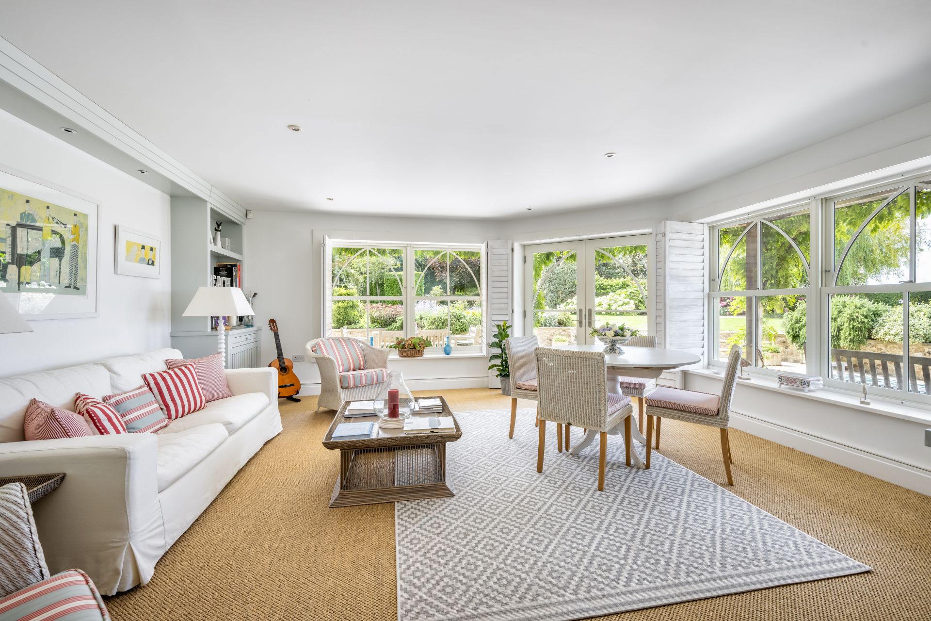 Living room with cream sofas, wooden floors and large bay windows