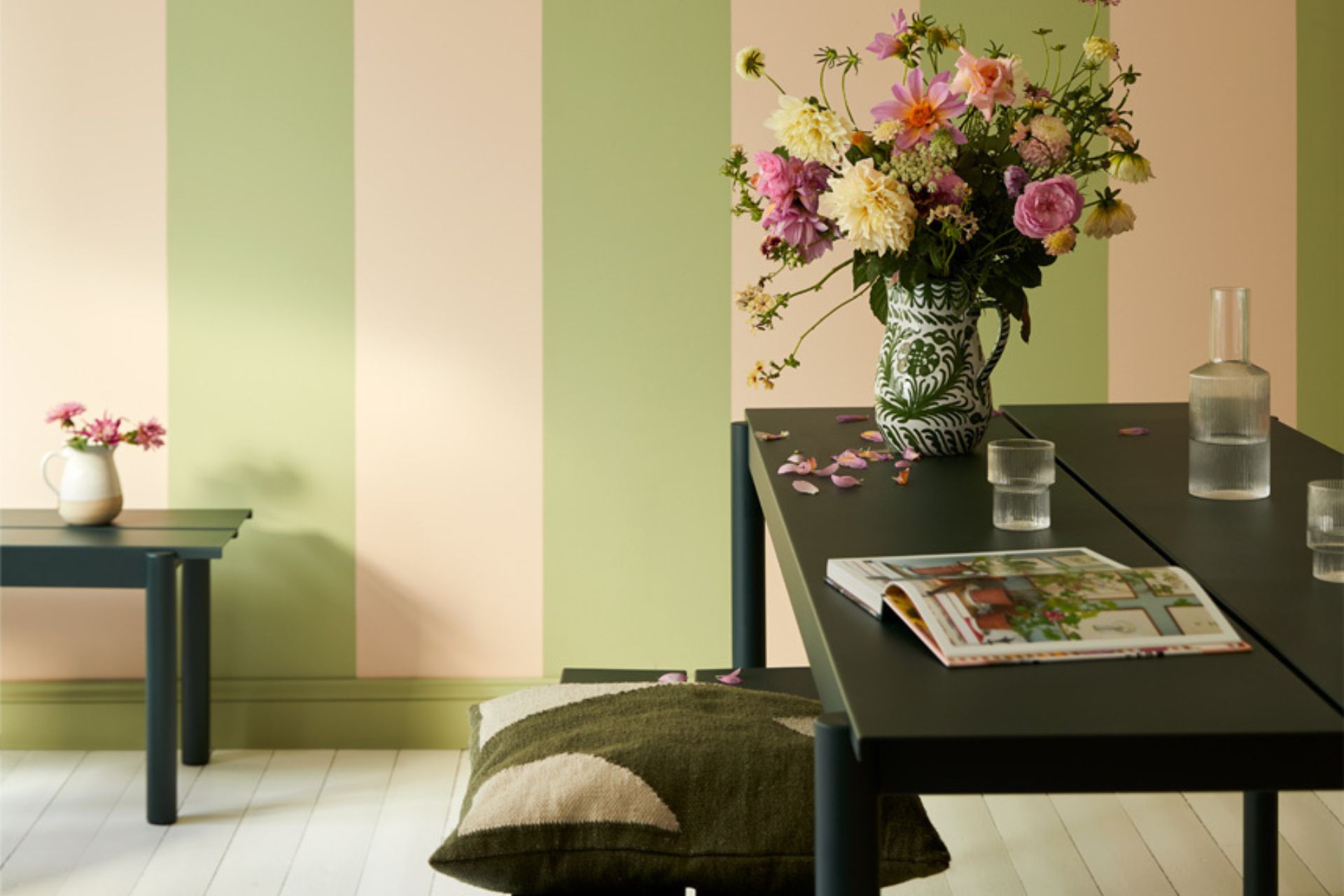 Living room with black wooden funiture and pale green and pink striped walls
