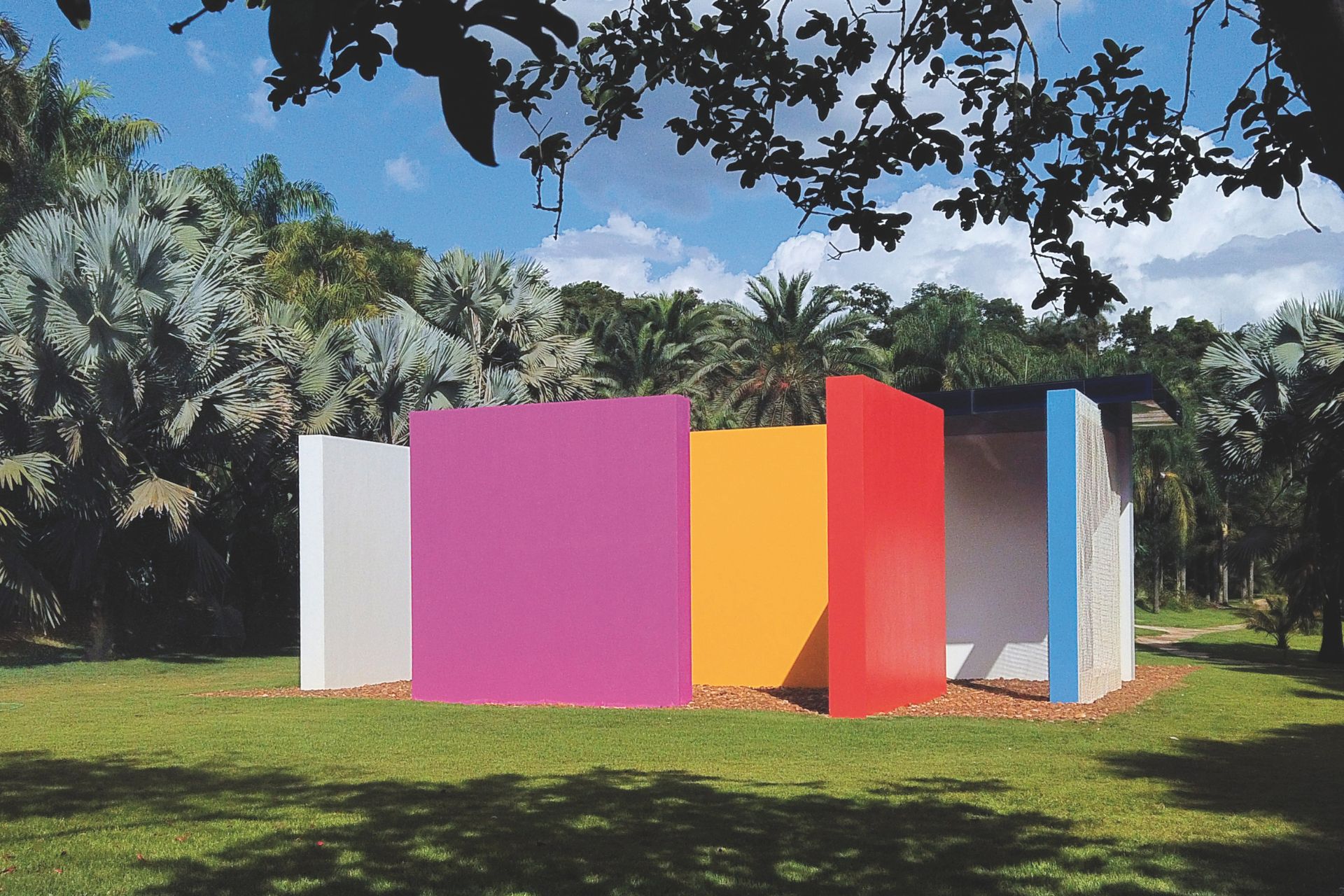 Outdoor sculpture made up of pink, yellow, blue red and white wooden panels