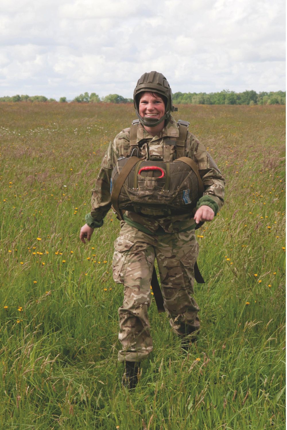 Young female soldier walking through a field