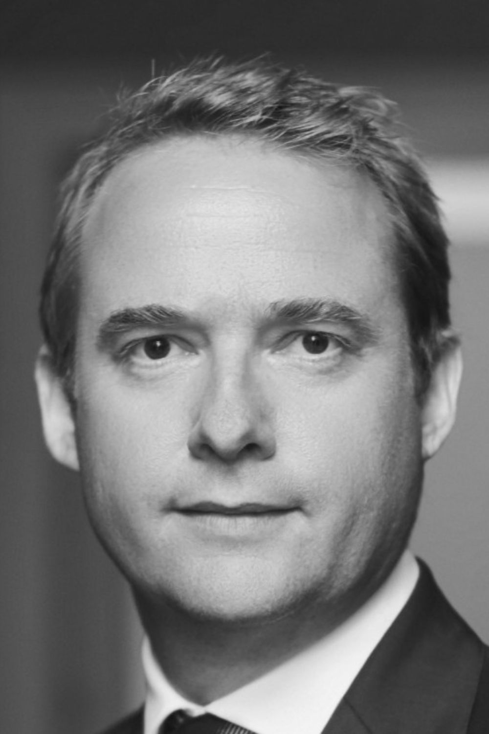 Black and white portait of Liam Bailey wearing a dark suit