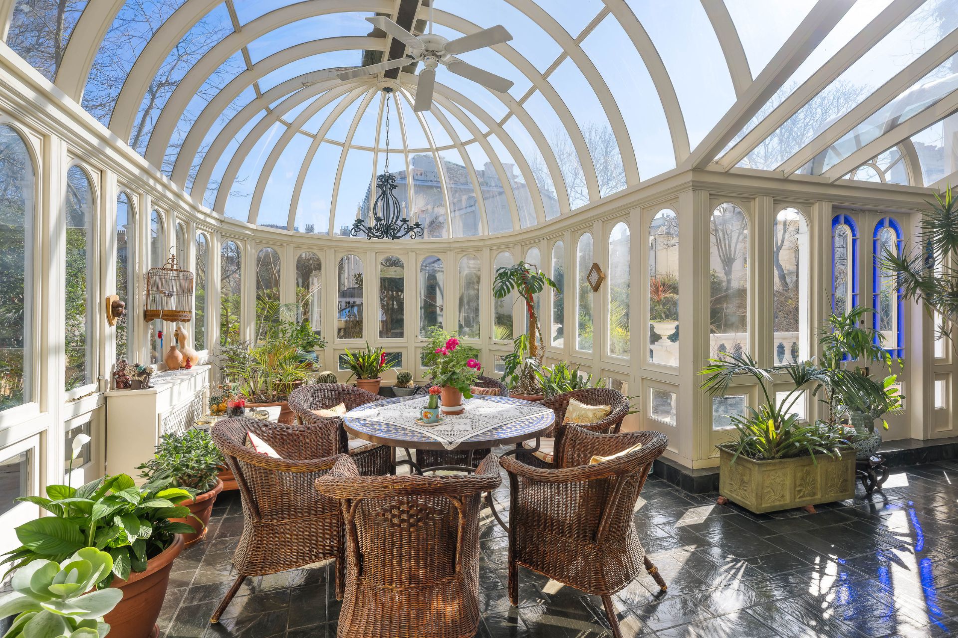 Domed orangery with wooden dining furniture and stone floors.