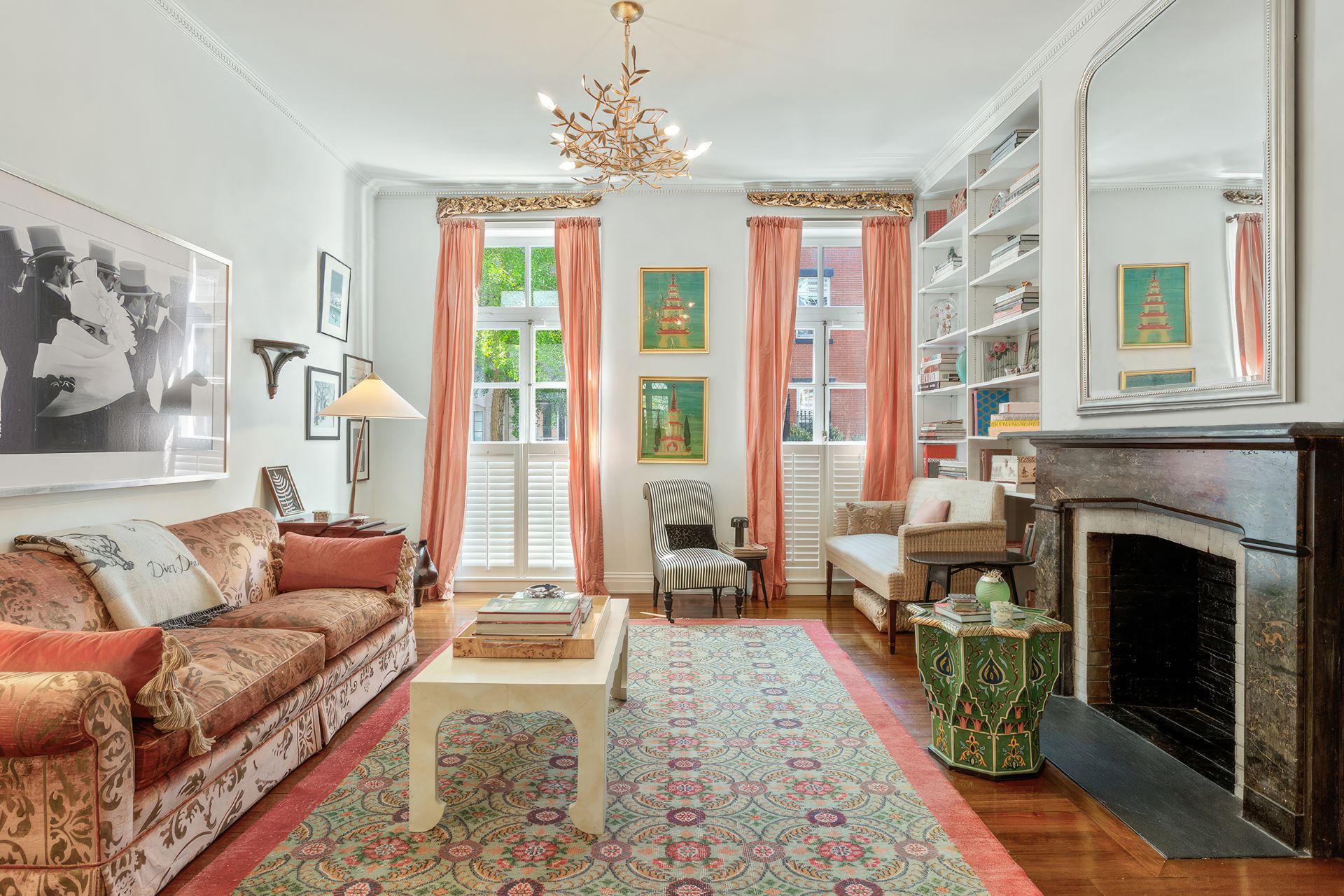 Living room with tall sash windows, a fireplace, and a chandelier