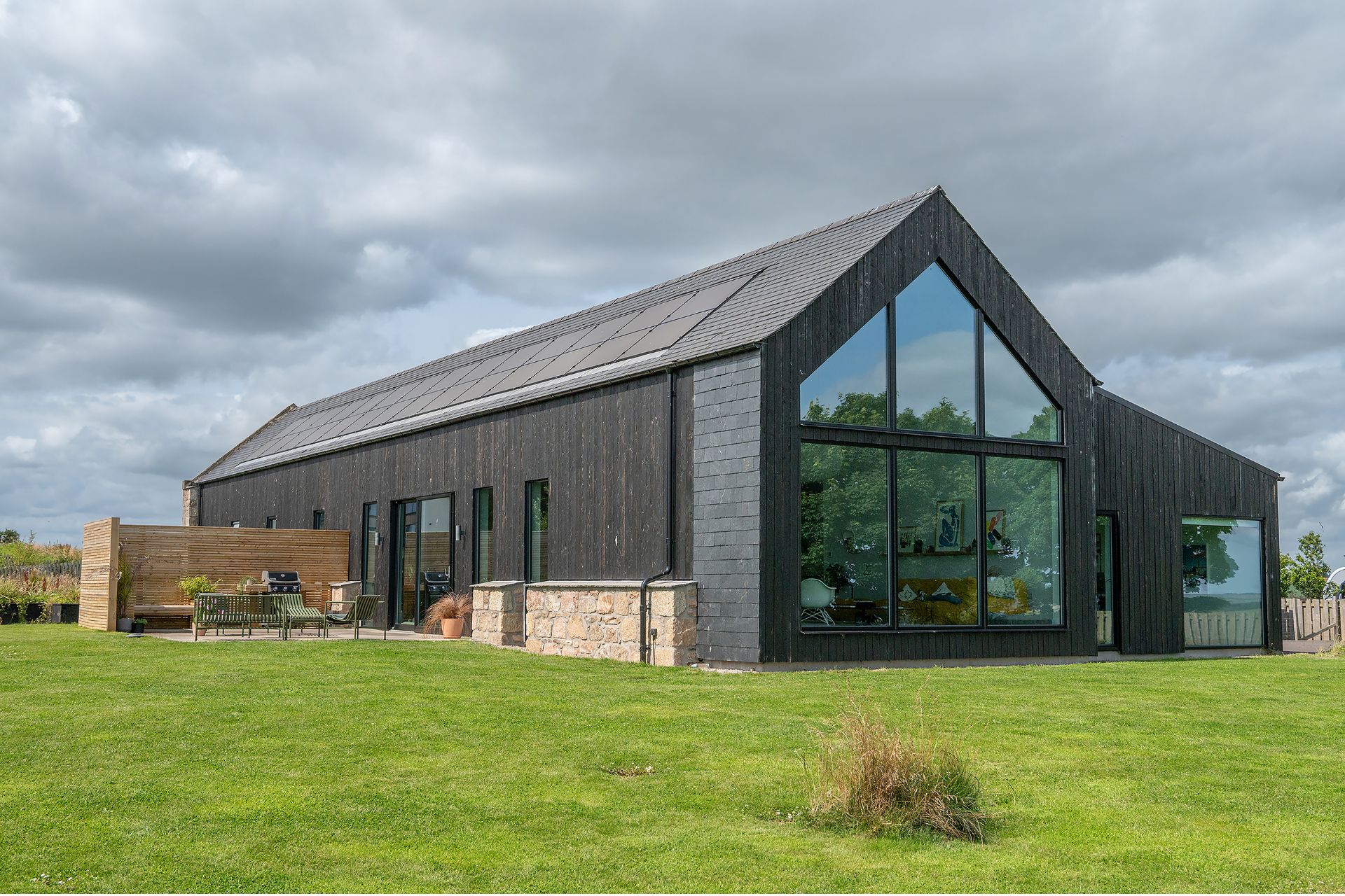 Modern barn conversion with black cladding and large windows
