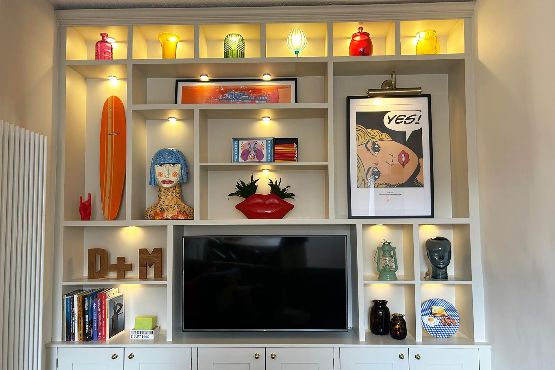 TV unit with in-built shelving and framed art pieces