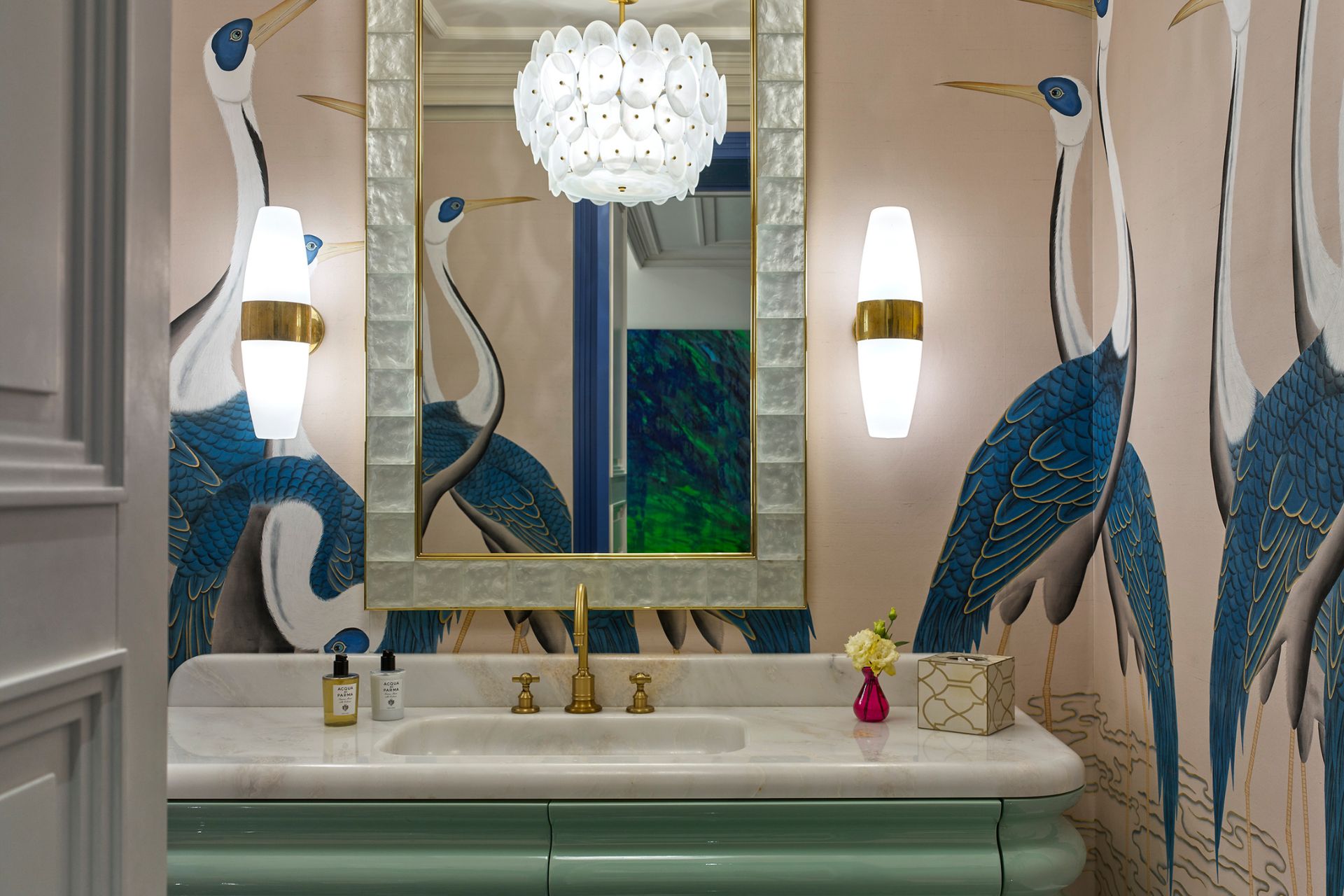 Powder room with green Art Deco vanity unit and pale pink wallpaper with flamingo design