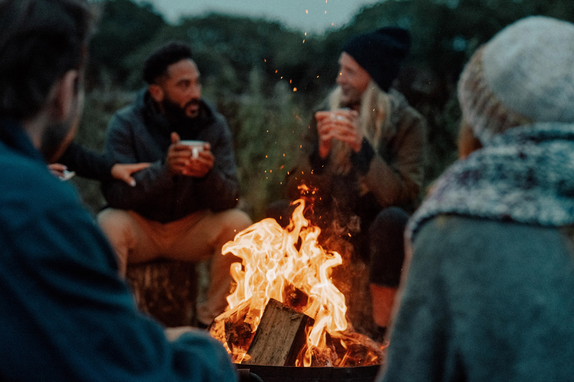 Group of people sitting around a campfire