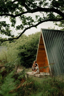 Two people sitting outside a cabin