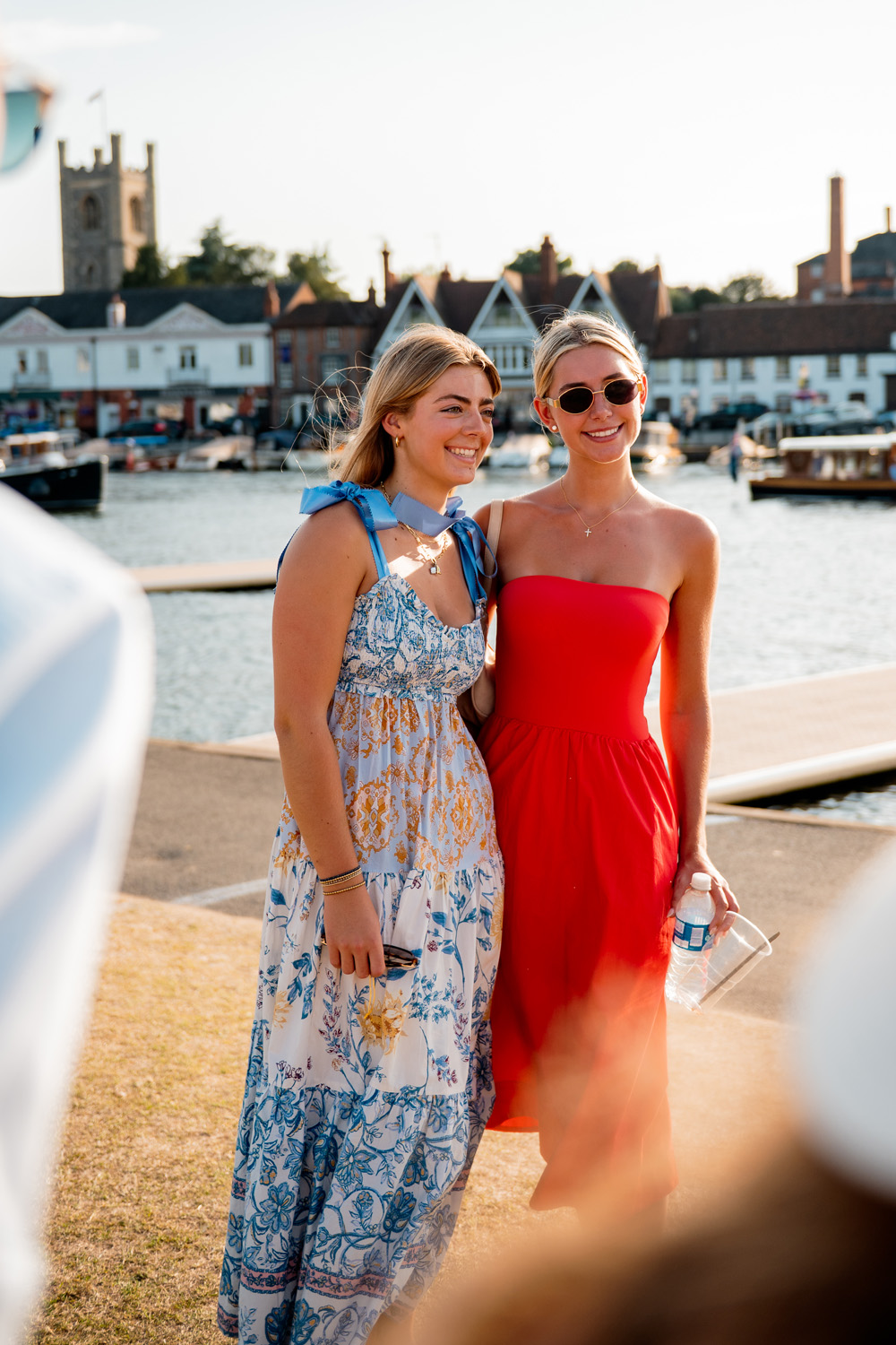 Two women in summer dresses on the bank at Henley Royal Regatta