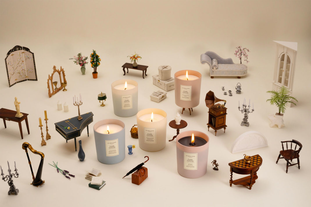 Collection of mood-paired candles by Jo Malone and Little Greene all laid out on a surface with tiny doll's house items