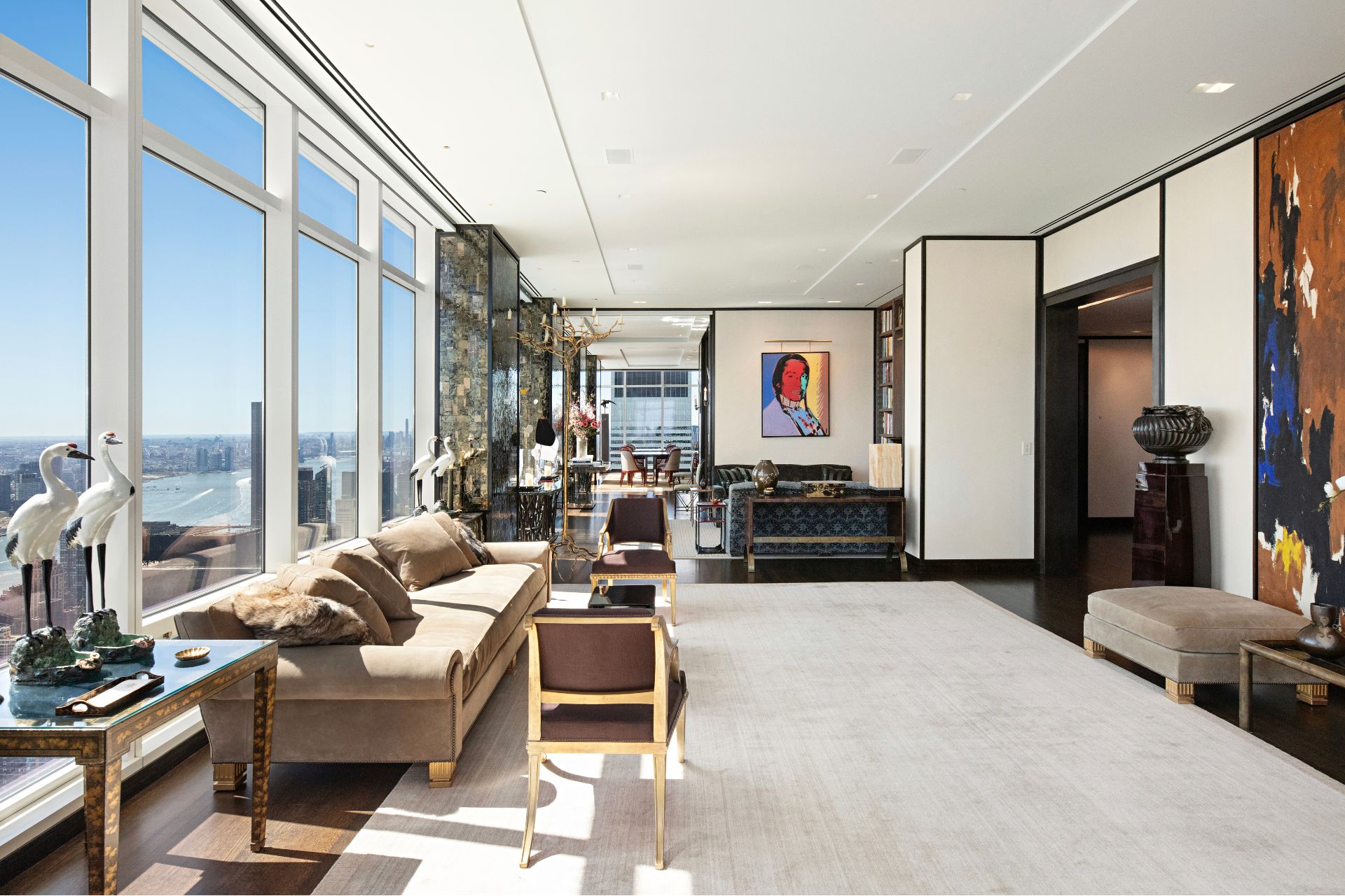 Living room with cream rug, taupe sofas and floor-to-ceiling windows