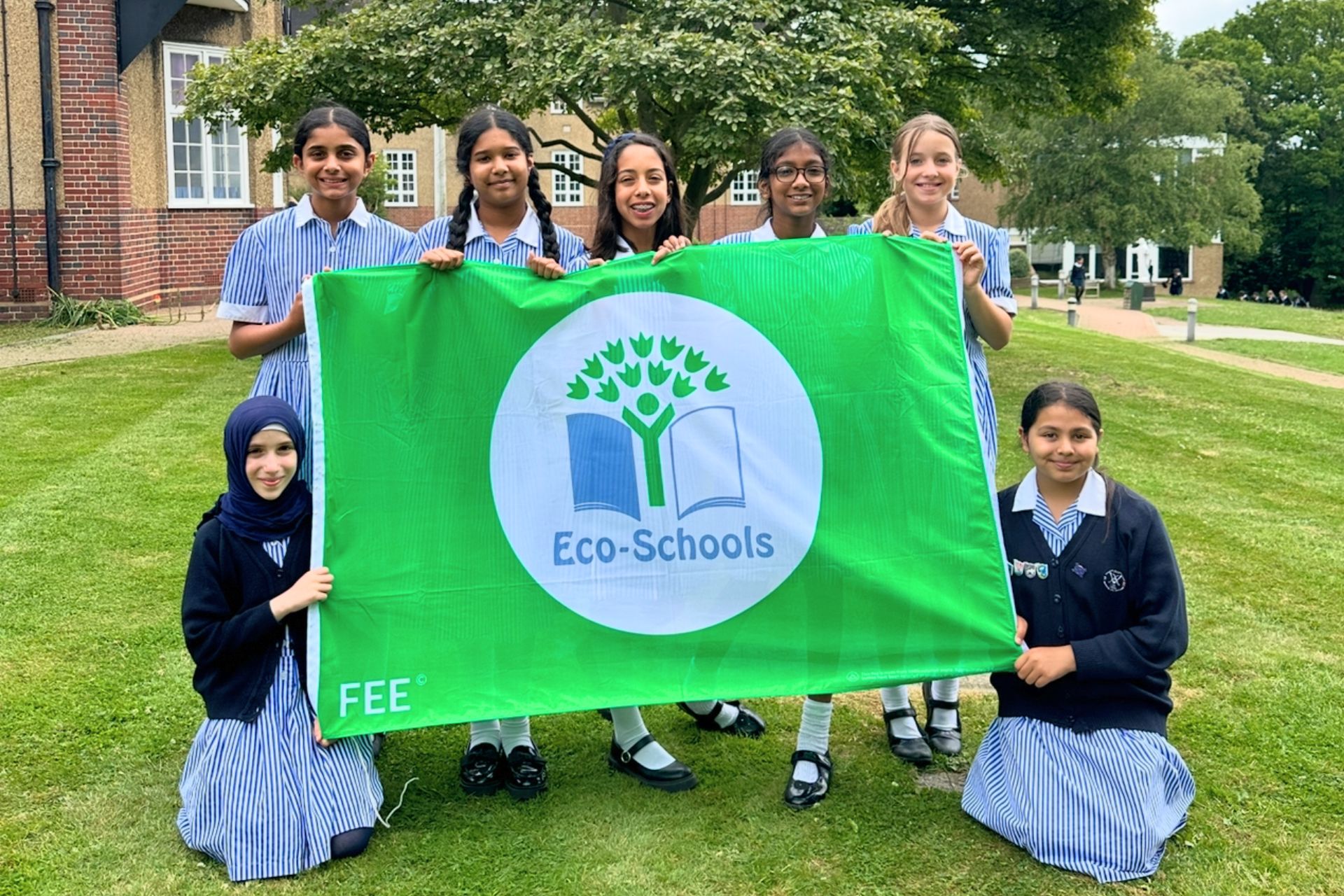 St Augustine's pupils holding up a big green Eco-Schools flag