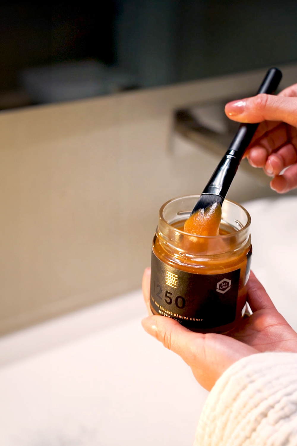Person dipping brush in honey