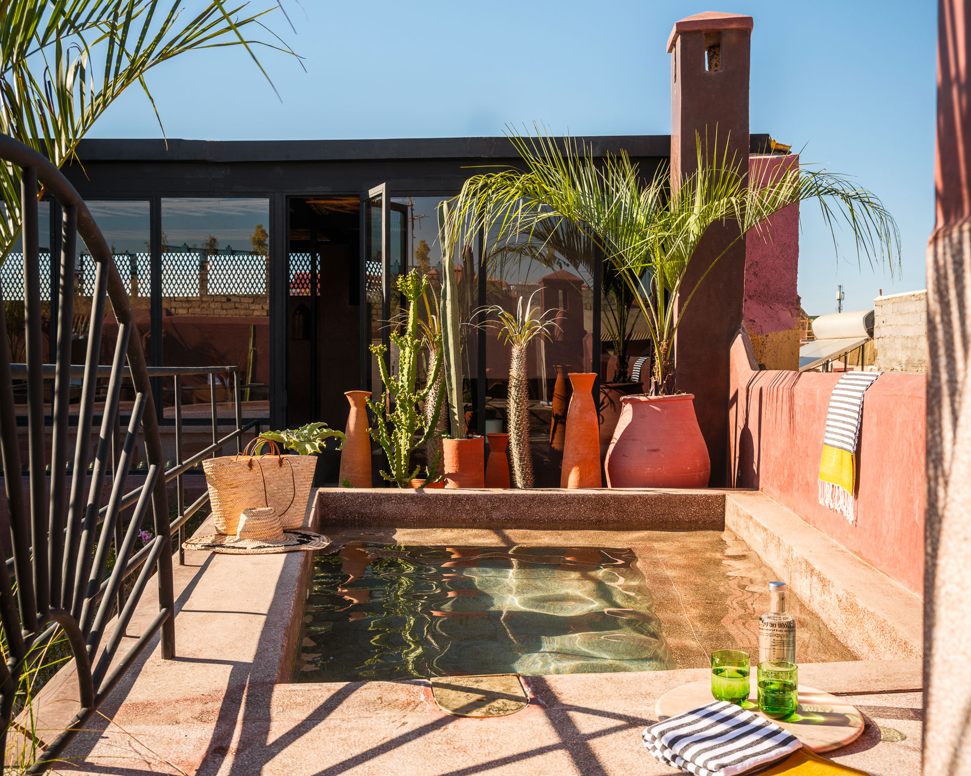 A small pool at Riad Brummell - the walls are pink and there are plants behind the pool.