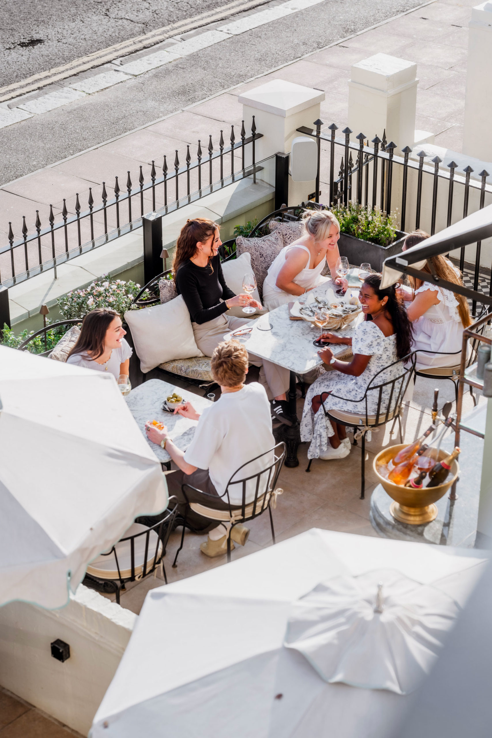 Outdoor dining terrace at Pearly Cow, Brighton, full of happy, laughing people