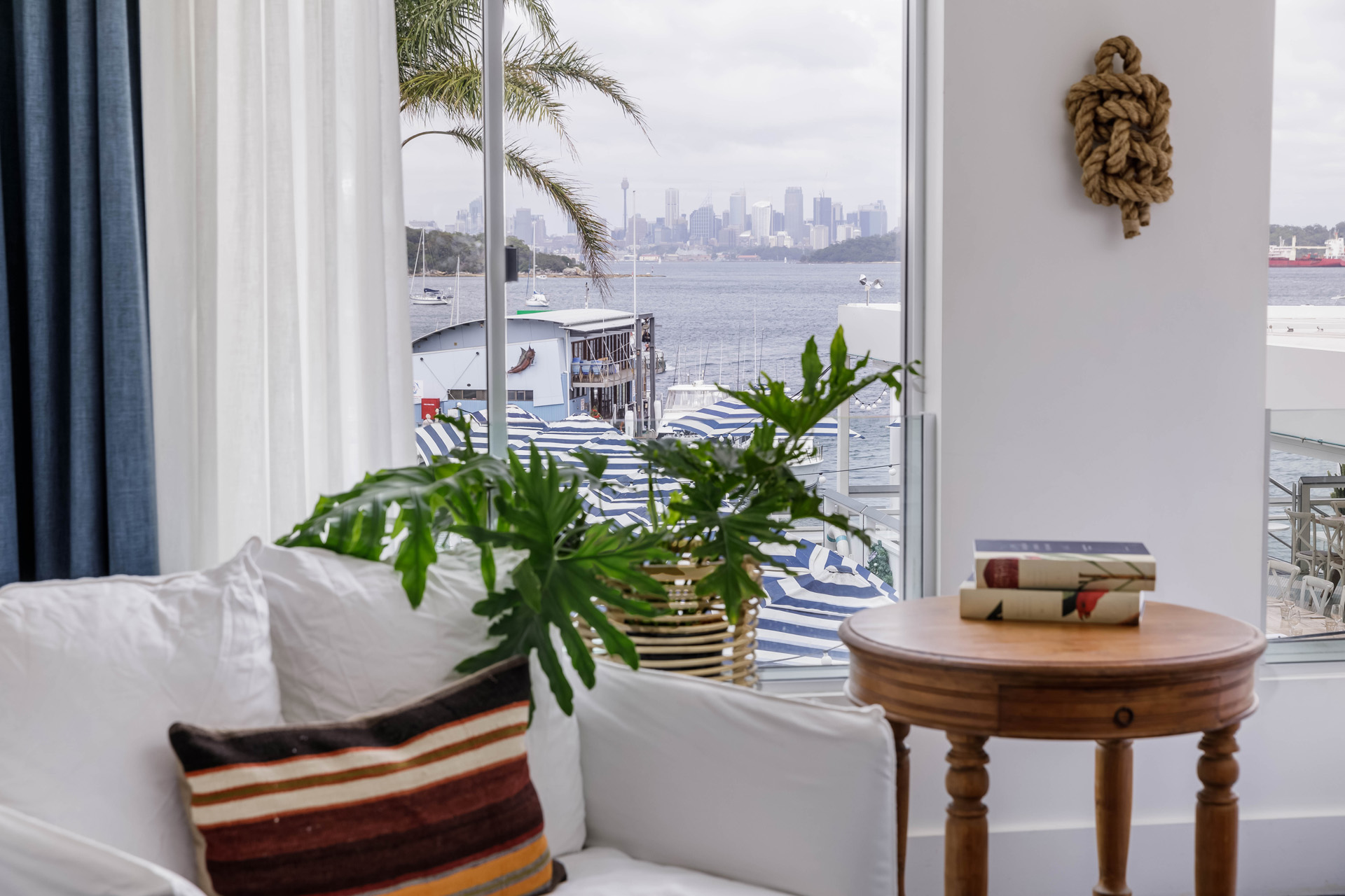 A sofa and window overlooking Sydney skyline in the distance