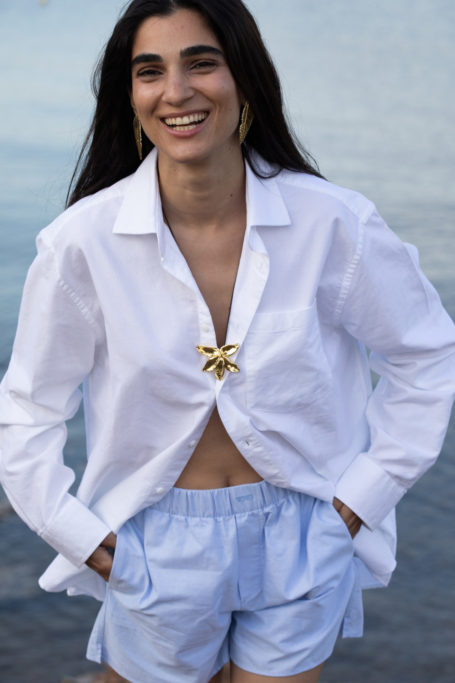 Woman wearing necklace over shirt and shorts