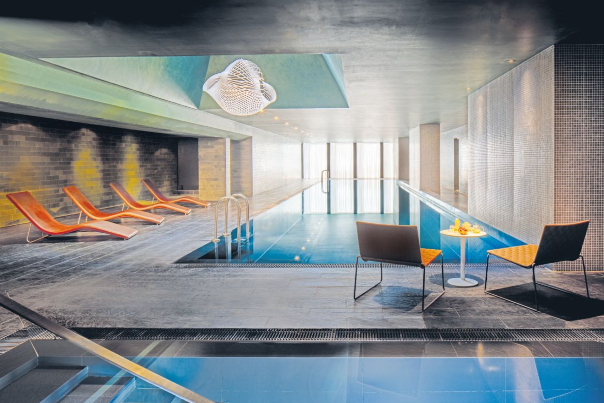 Hotel pool with jacuzzi and orange sun loungers