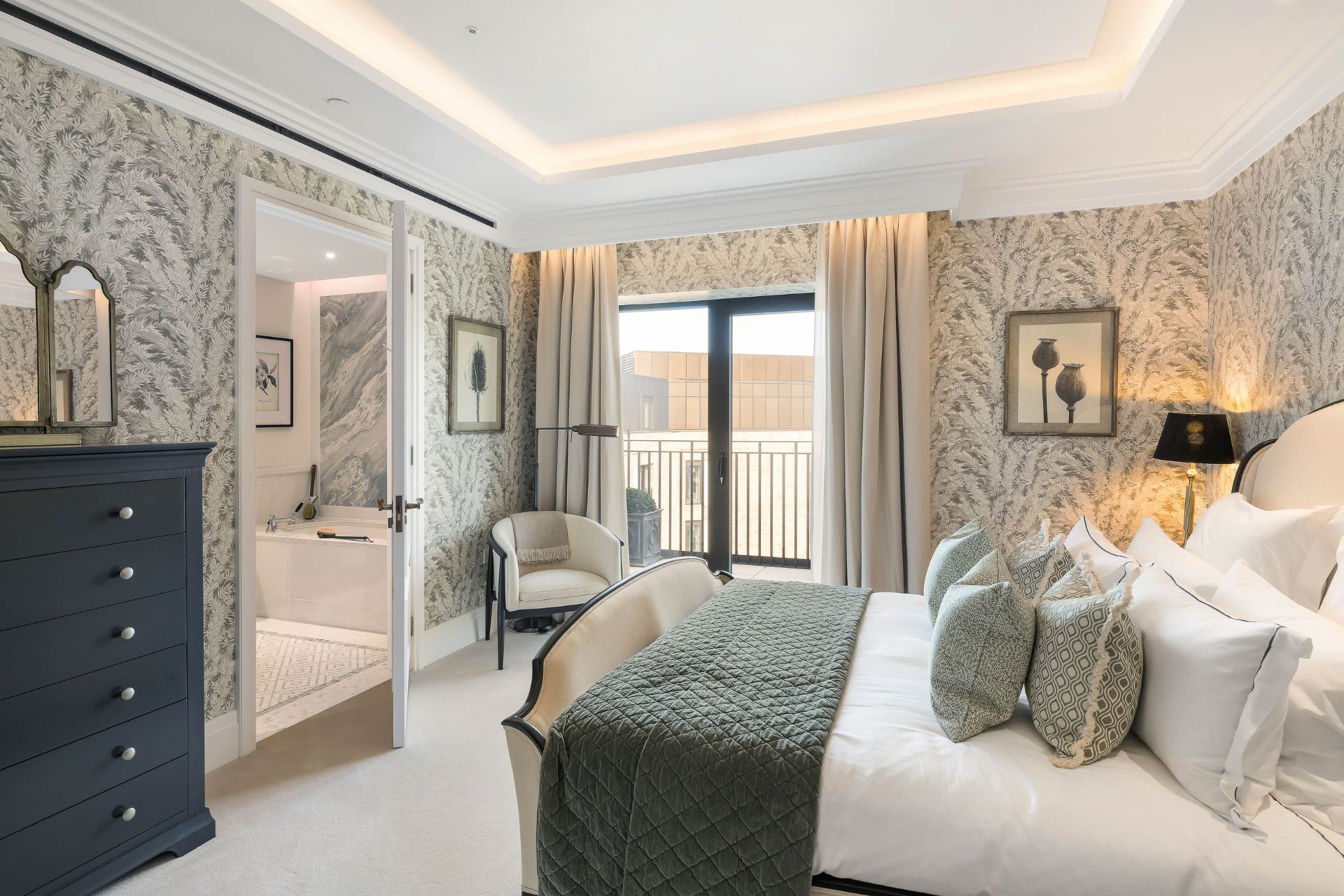 Bedroom with green and white floral wallpaper, a green bedspread and a mirrored wardrobe