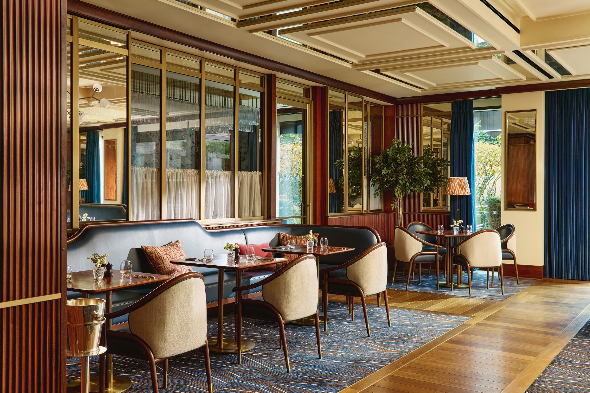 Restaurant with curved cream armchairs, parqet floors and wooden wall panelling
