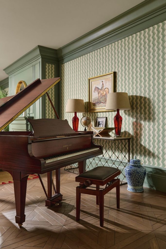 Living room with grand piano and green and white wallcoverings