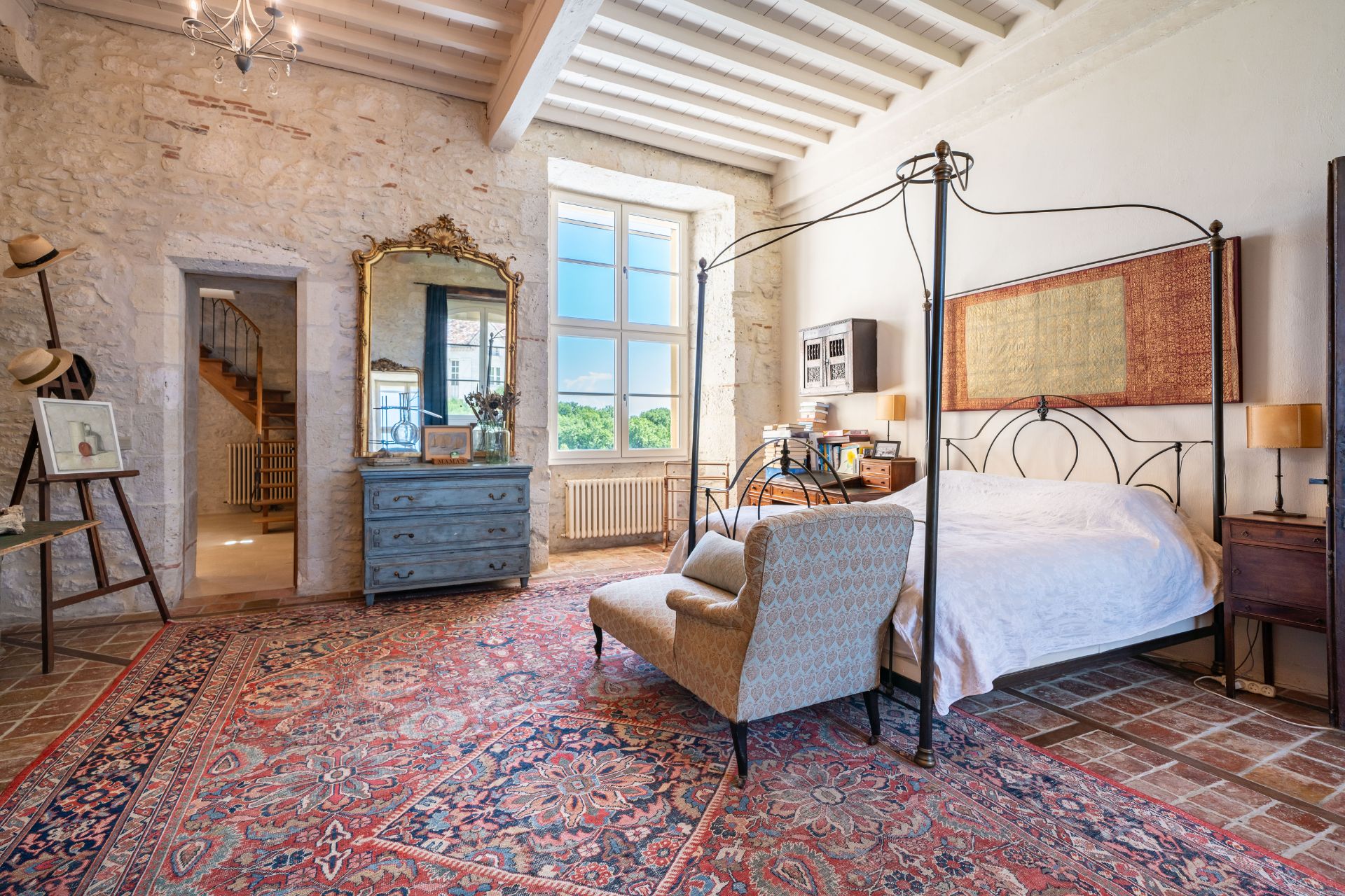 Bedroom with Persian rug, wooden ceiling beams and a four poster bed