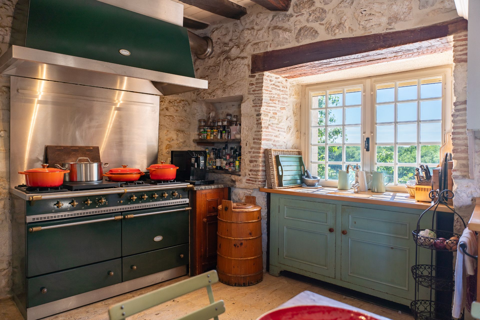 Kitchen with stone walls, duckegg blue cabinets and a black range cooker