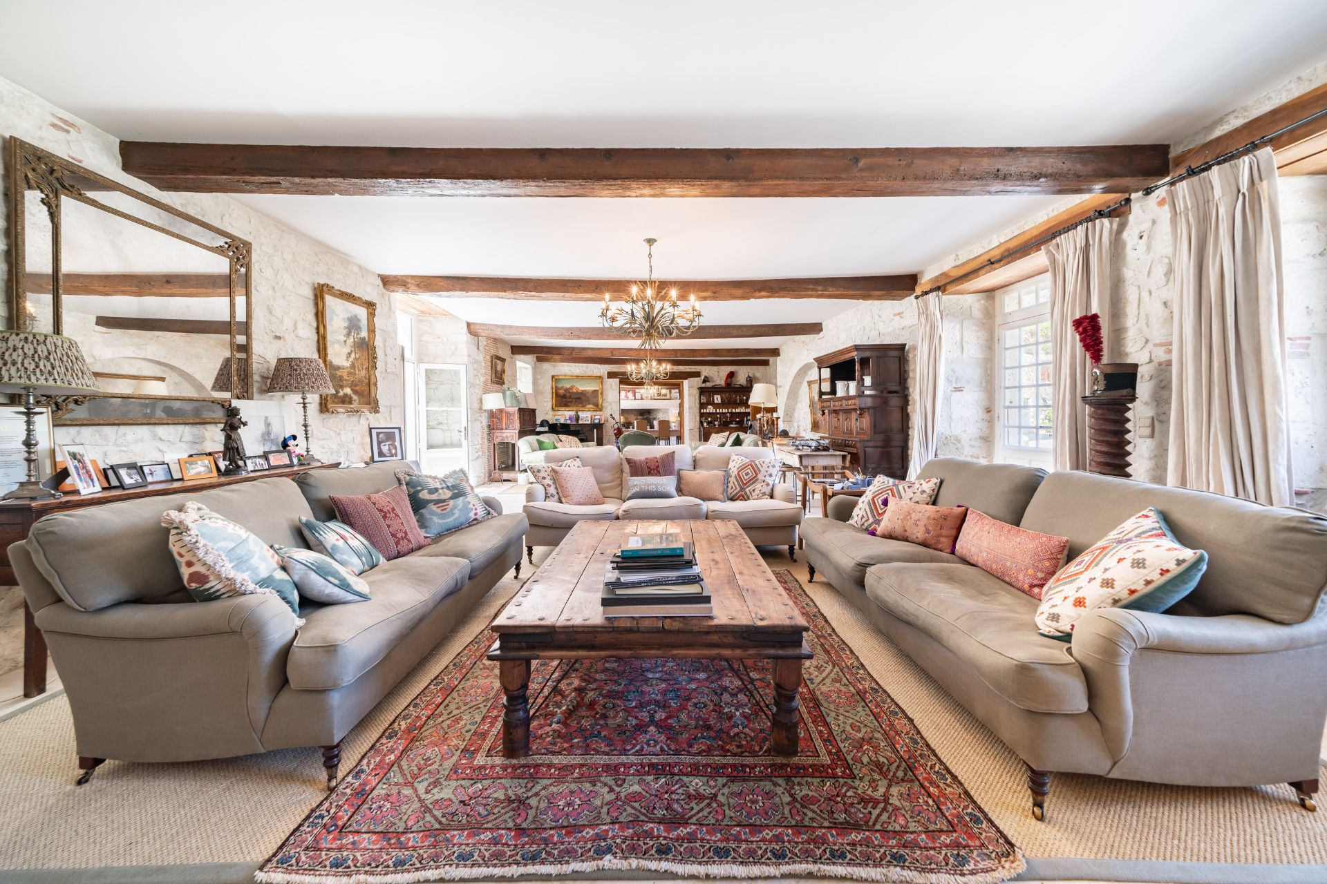 Chateau living room with grey sofas, wooden floors and wooden ceiling beams