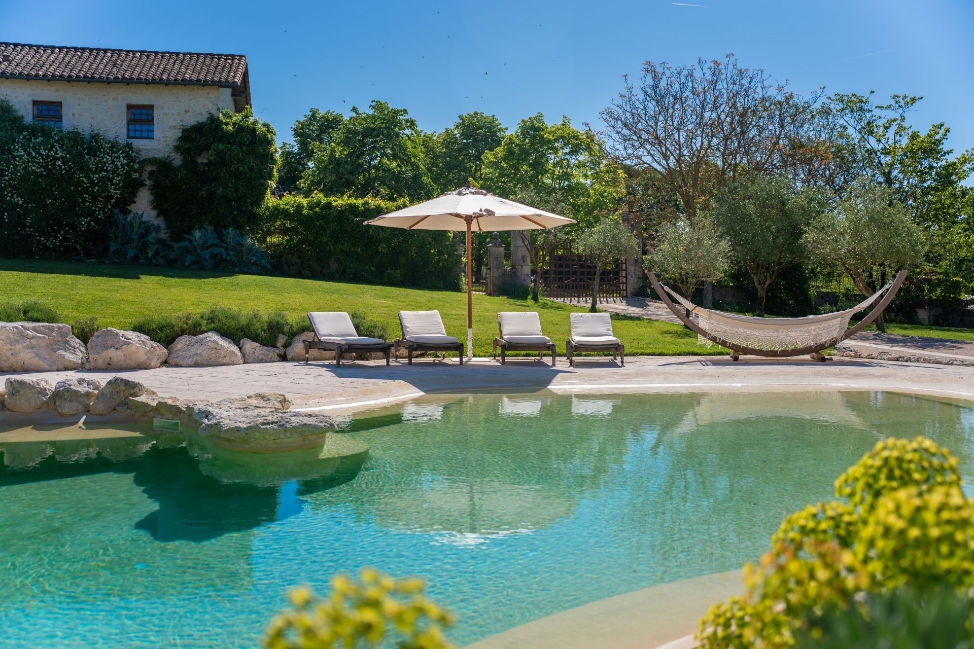 Outdoor swimming pool with sun loungers and a hammock