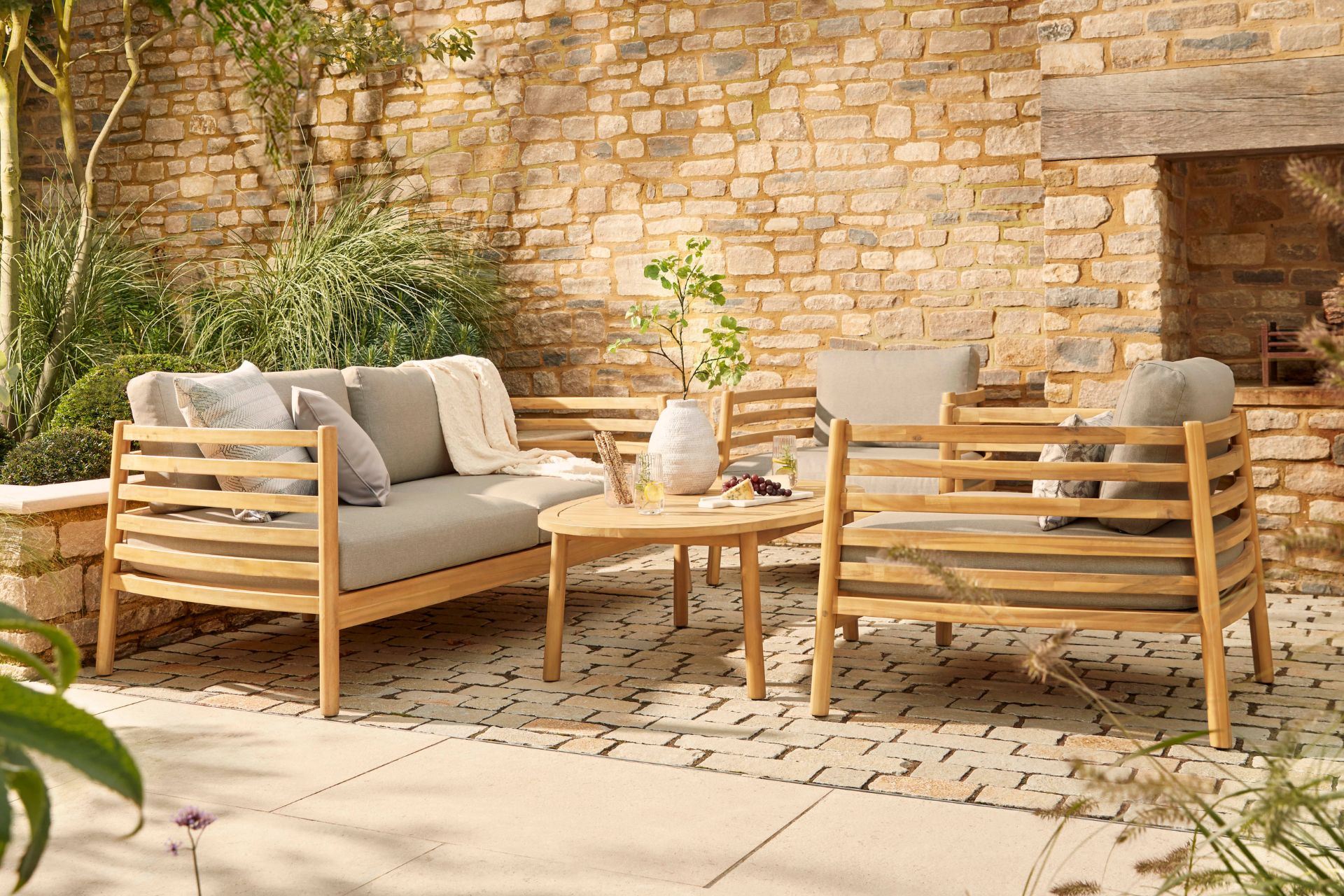 Wooden outdoor dining set with grey cushions