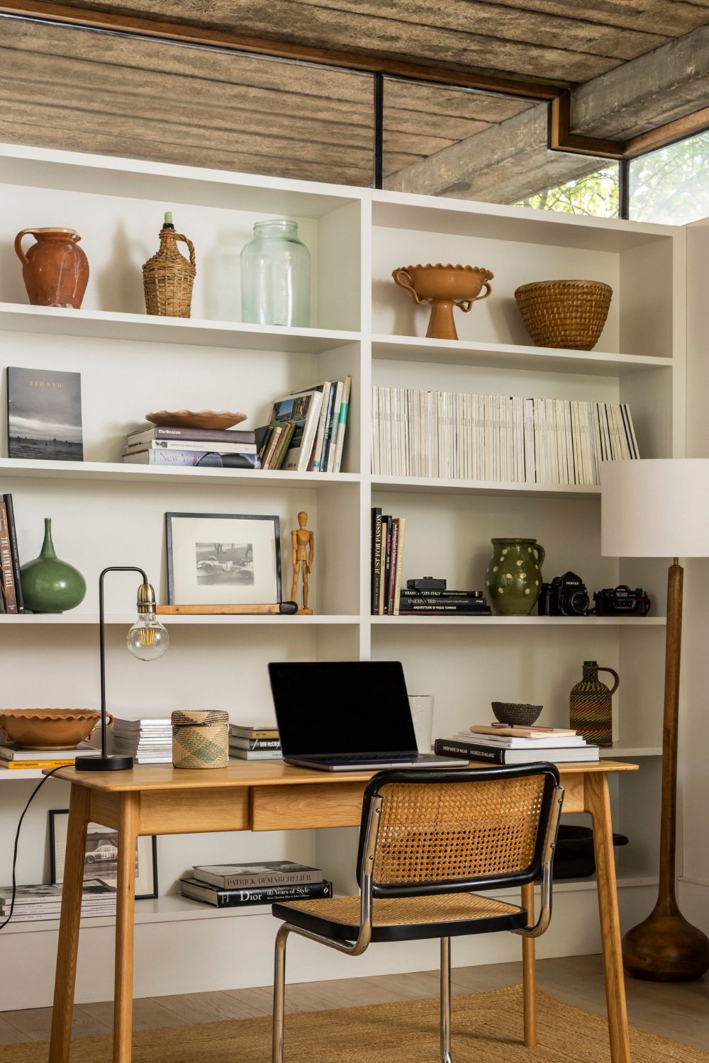 Desk area with wooden furniture and a white shelving unit