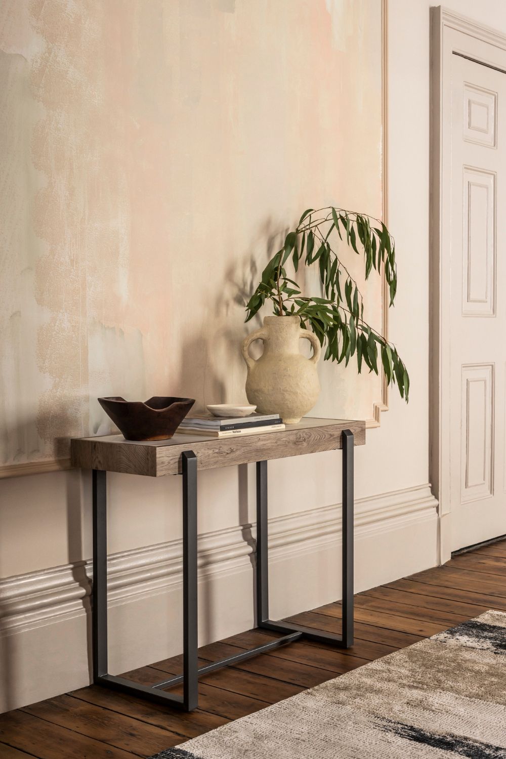 Hallway with whitewashed walls and a pale oak sideboard with a cream plant pot