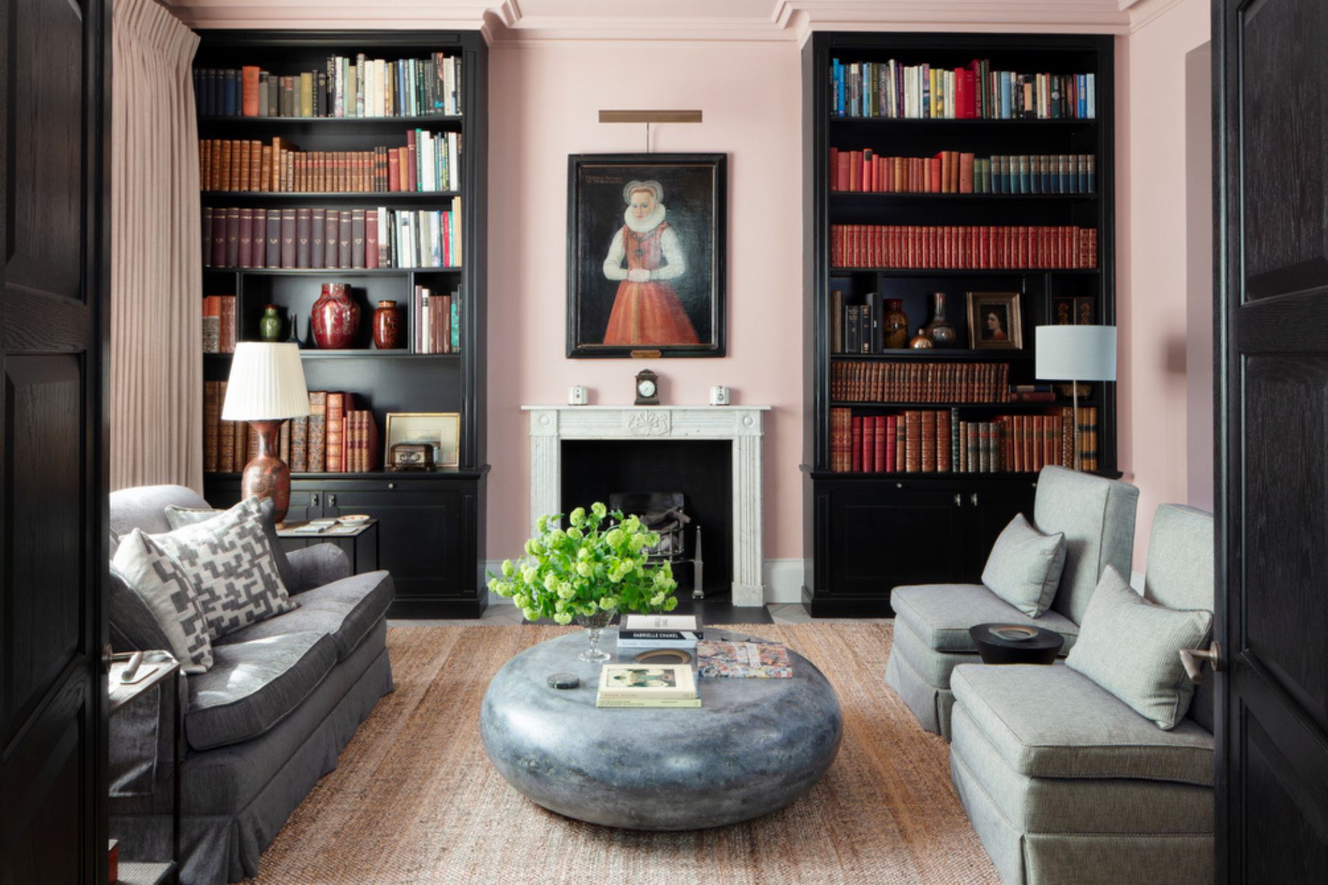 Drawing room with antique books, grey sofas and a grey pebble coffee table