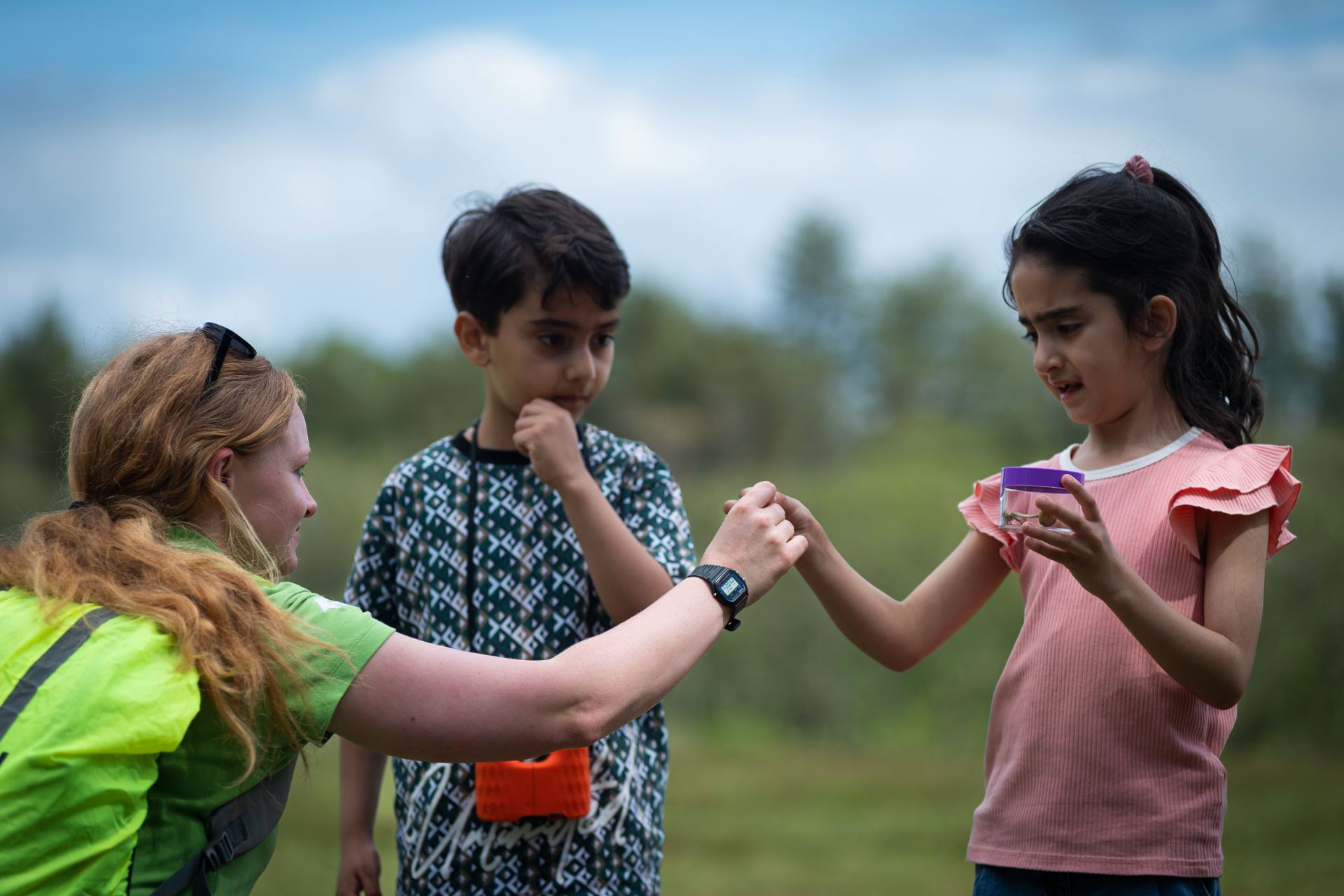 Femalr ranger working with two young children