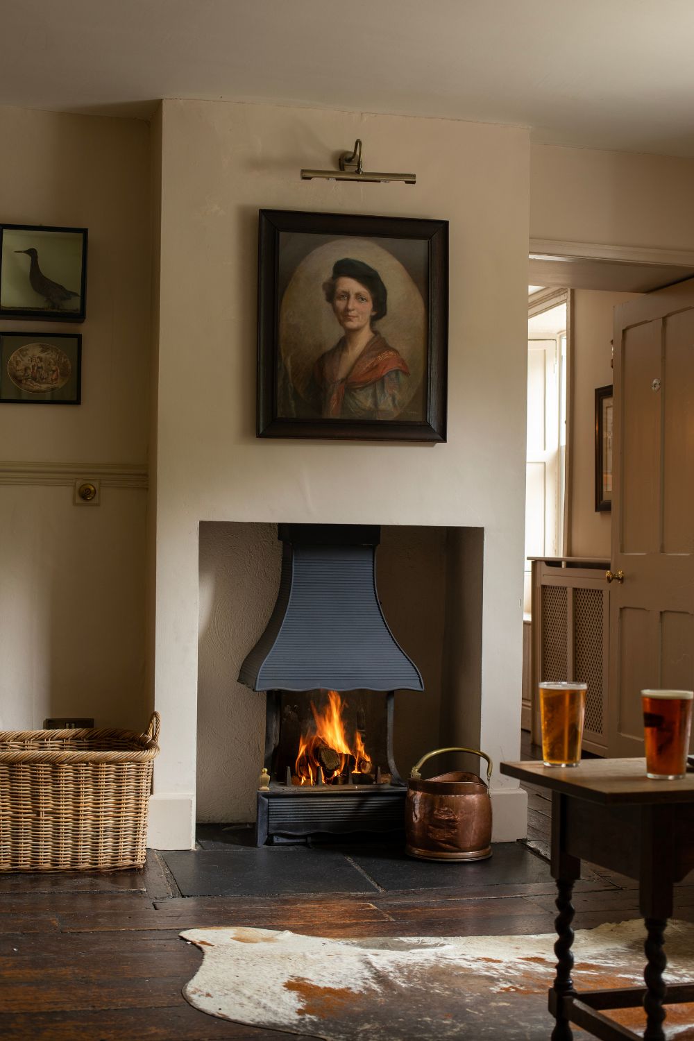 Country house hotel dining area with wooden furniture, stone floors and a fireplace