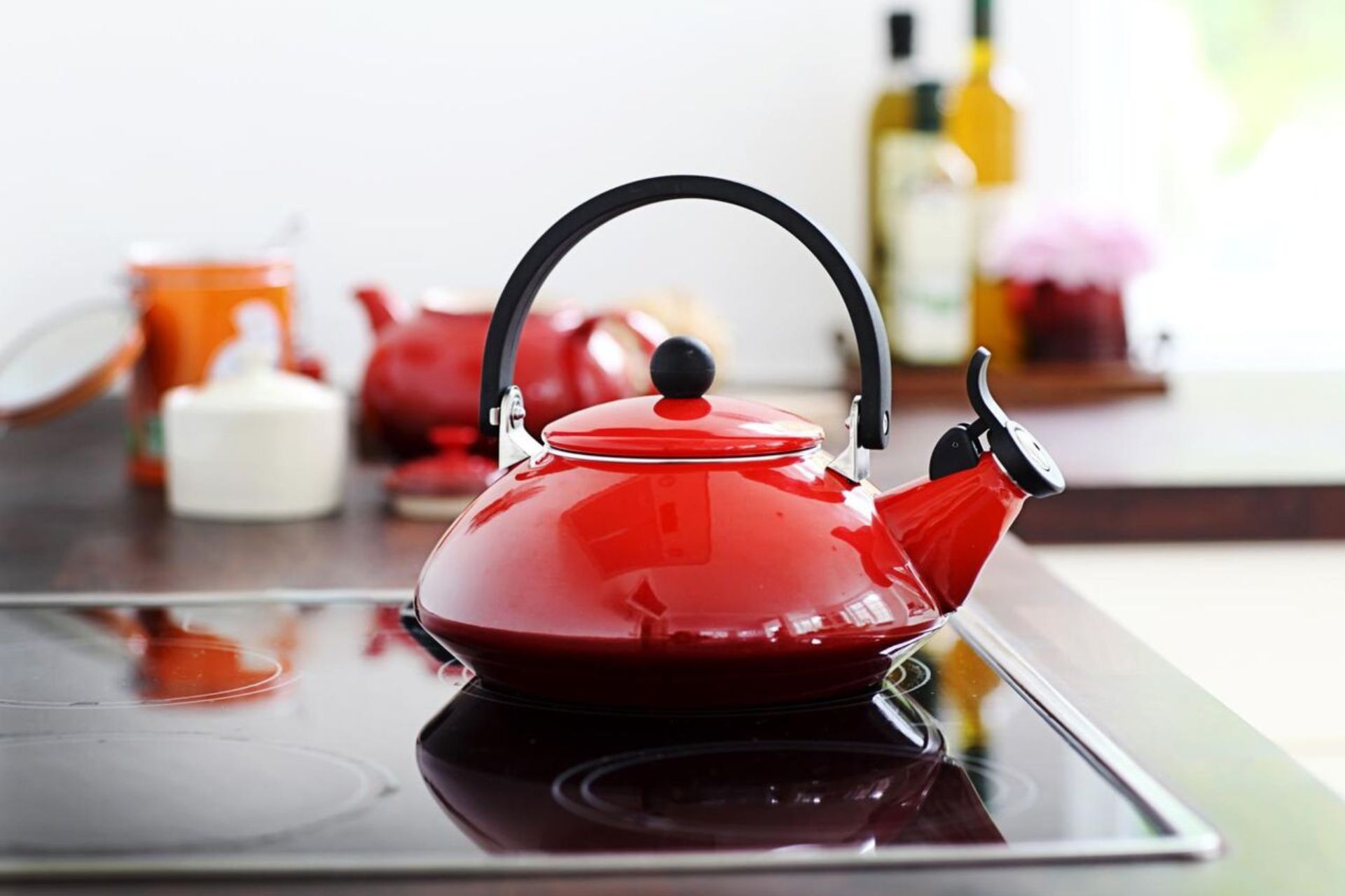 Red Le Creuset kettle on an induction hob