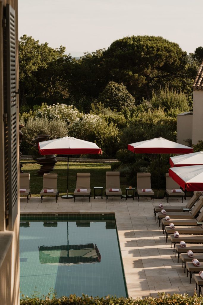 St Tropez hotel with pool and red-trimmed parasols